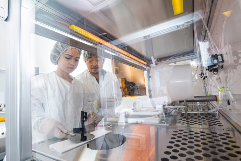 Scientists working with advanced nanofabrication technology in a laboratory setting