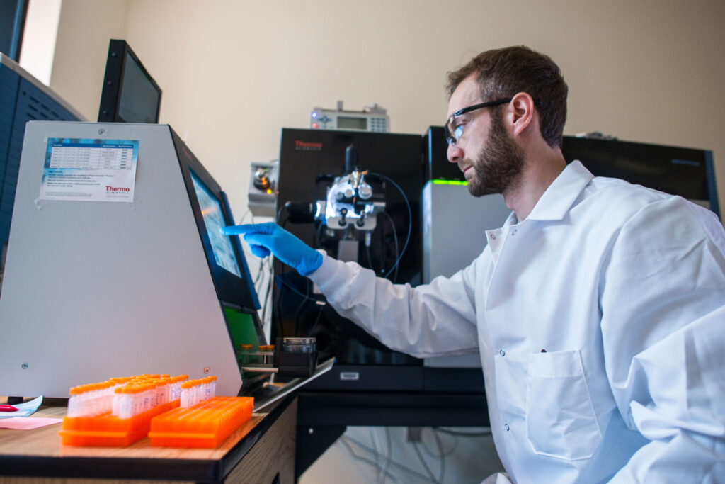 Researcher operating laboratory equipment in a research lab